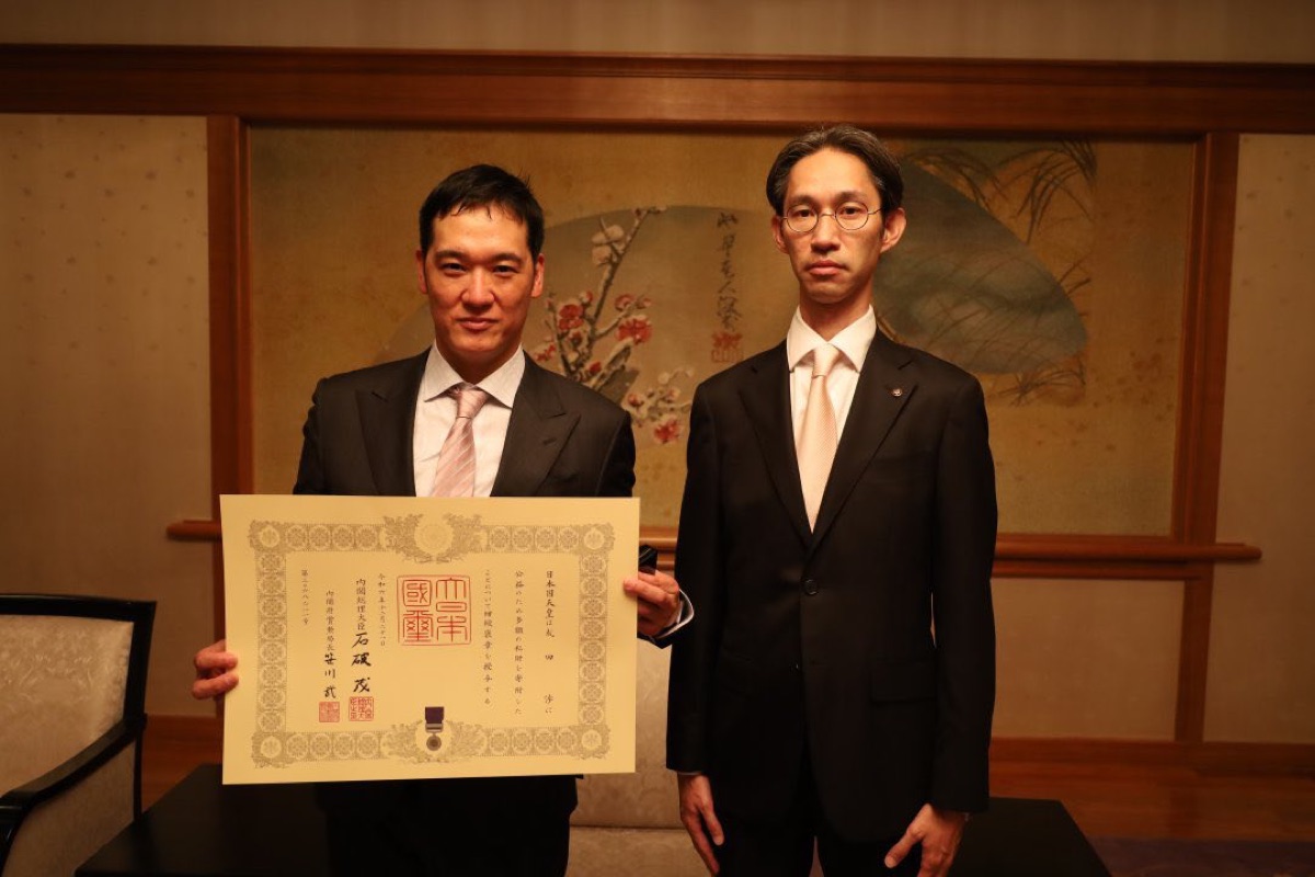紺綬褒章の伝達を受けた成田渉代表